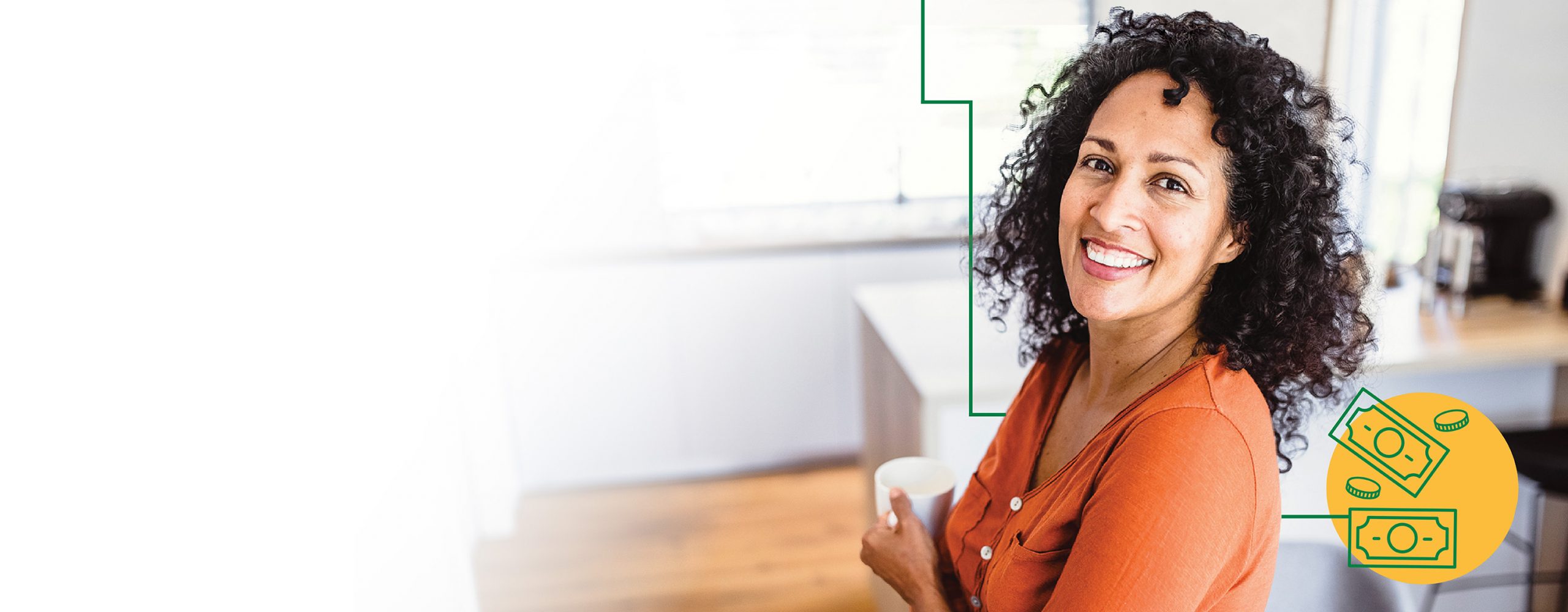 A woman holding a coffee cup in her kitchen and smiling.