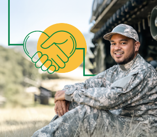 A veteran sitting on the ground in uniform with a smile on his face.